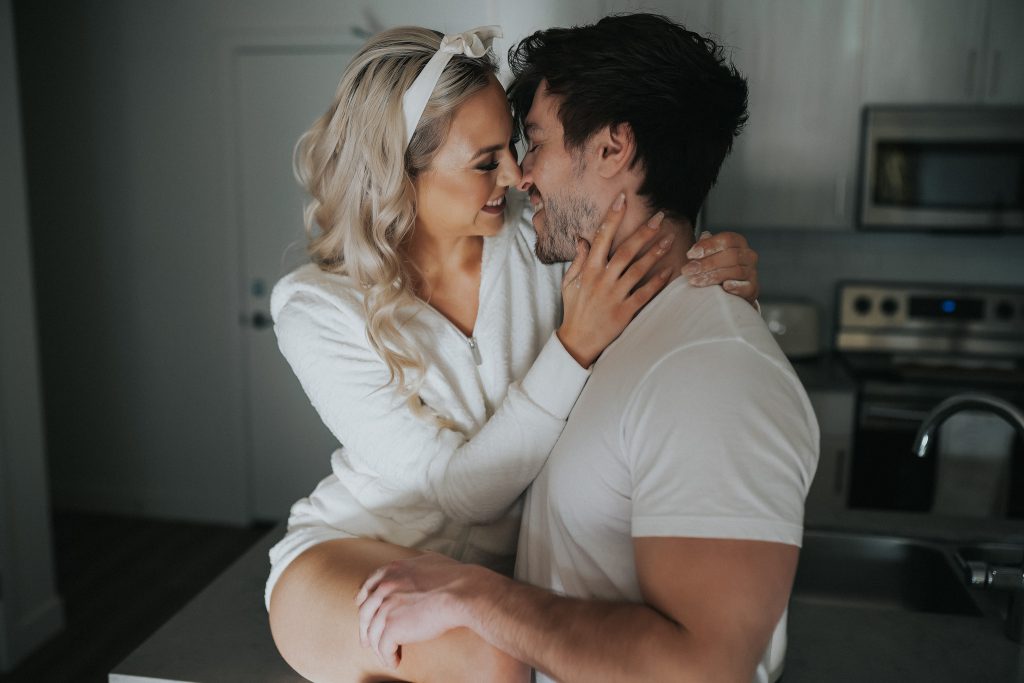 Couple wearing white looking into each other's eyes