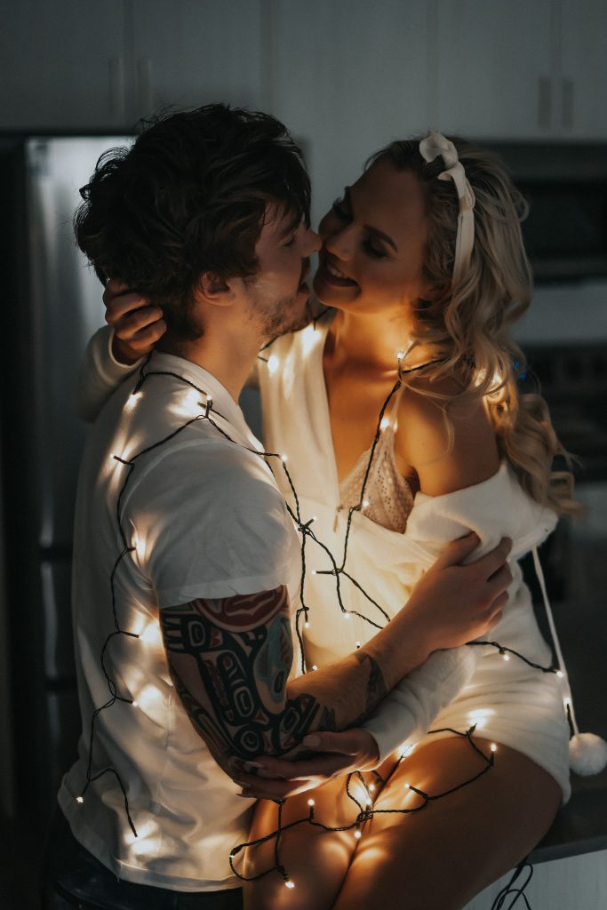 Couple cuddling with twinkle lights