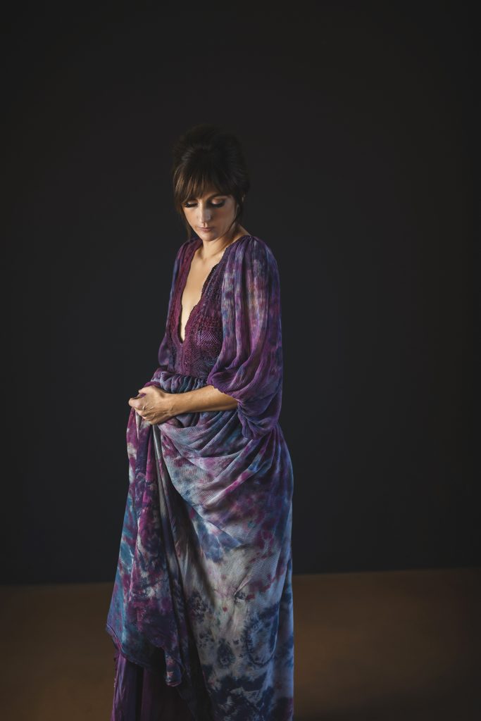 Boudoir portrait of woman in purple dress.