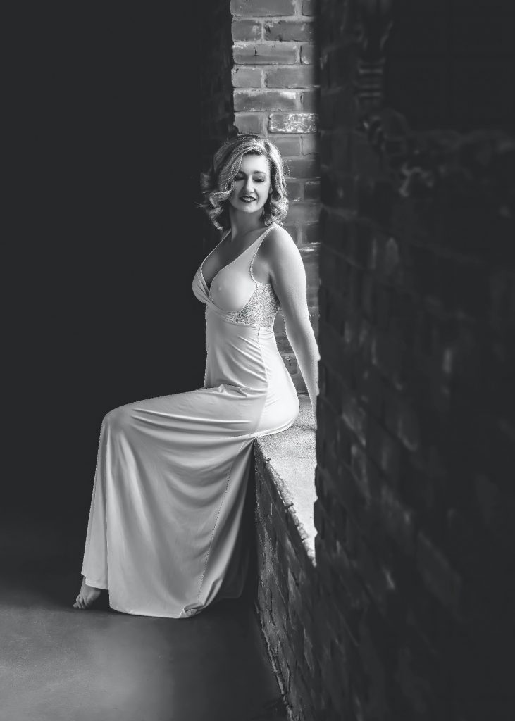 black and white image of woman posing in white dress