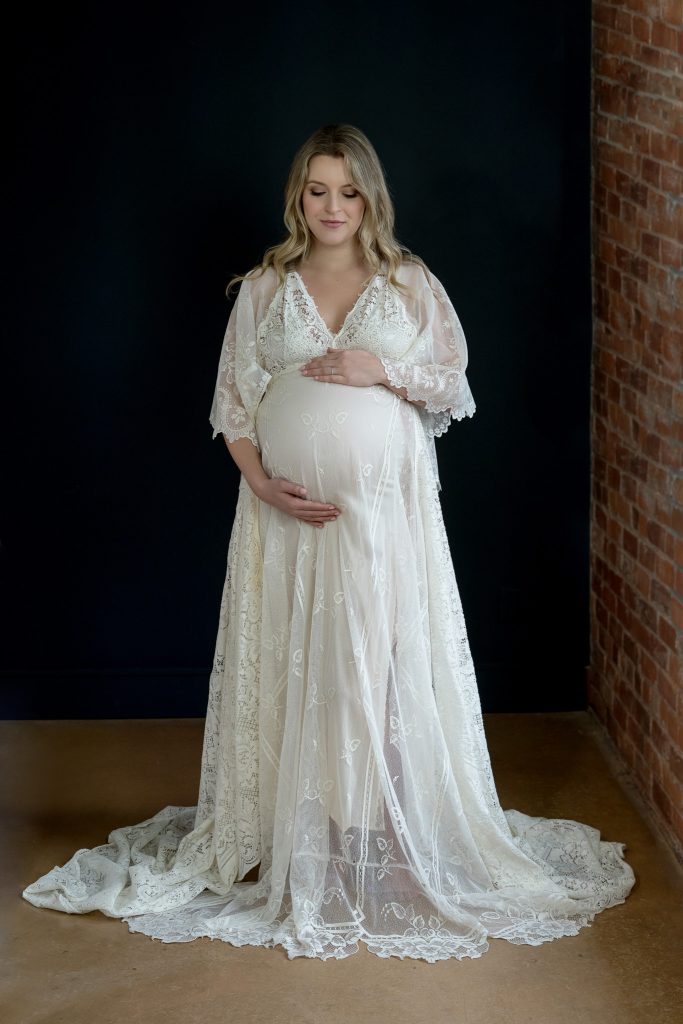 full body maternity portrait wearing white gown