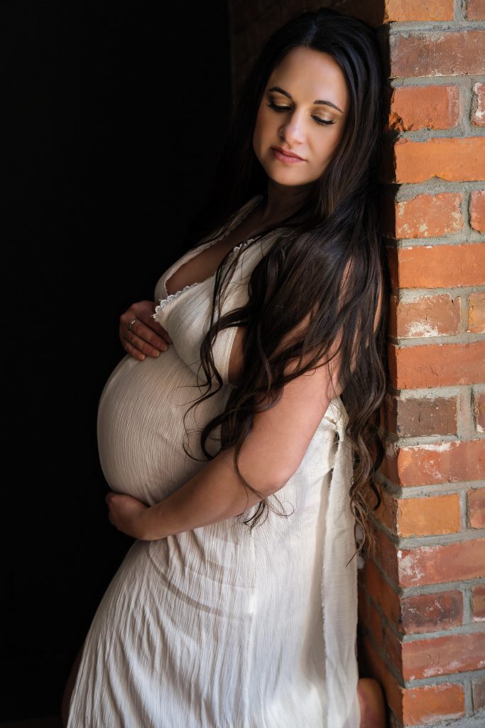 pregnant woman posing by window