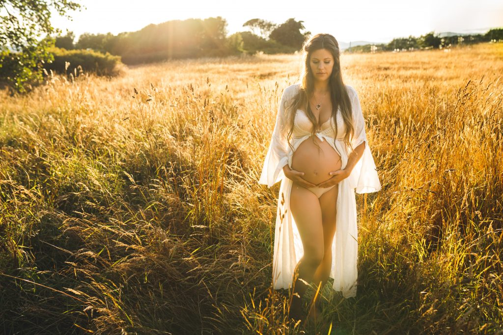 woman posing with belly in field